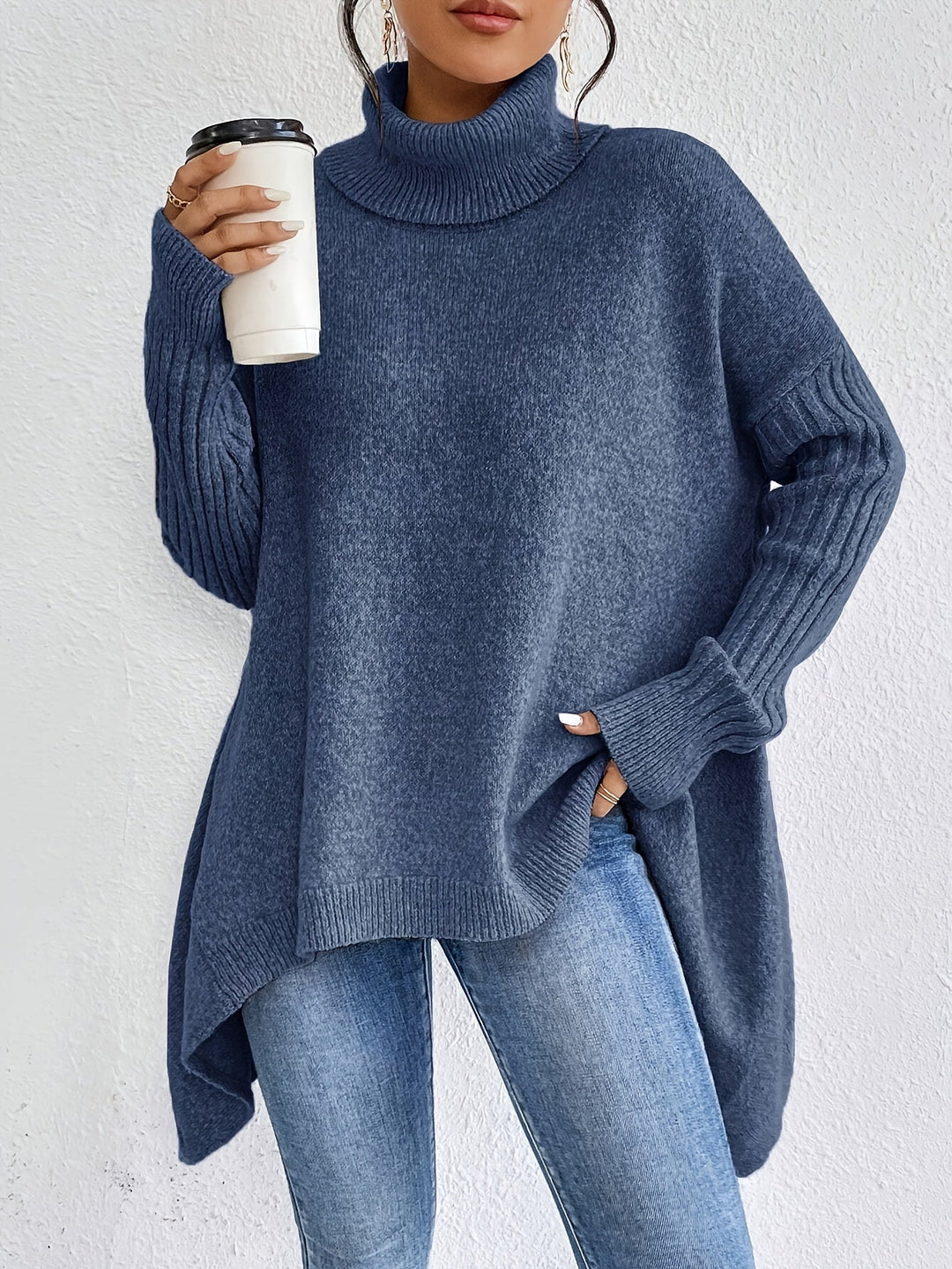 A woman wearing a stand-collar jumper with a chic asymmetric drape, warm and polished.