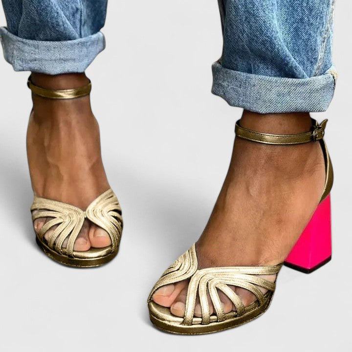 A woman wearing gold open-front heels with an ankle strap, dressed for a special evening.