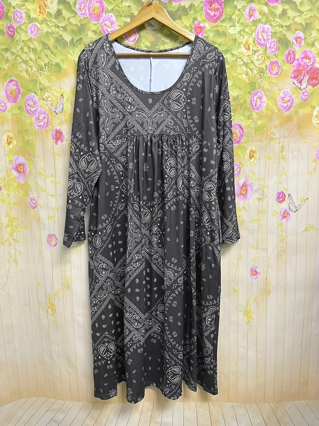 A woman wearing the Maureen long sleeve grey paisley midi dress with a square neckline and flowing skirt, styled for a relaxed day out.