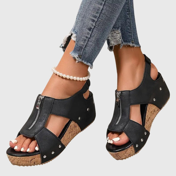 A woman standing at ease in wide-fit supportive comfort sandals with adjustable straps.