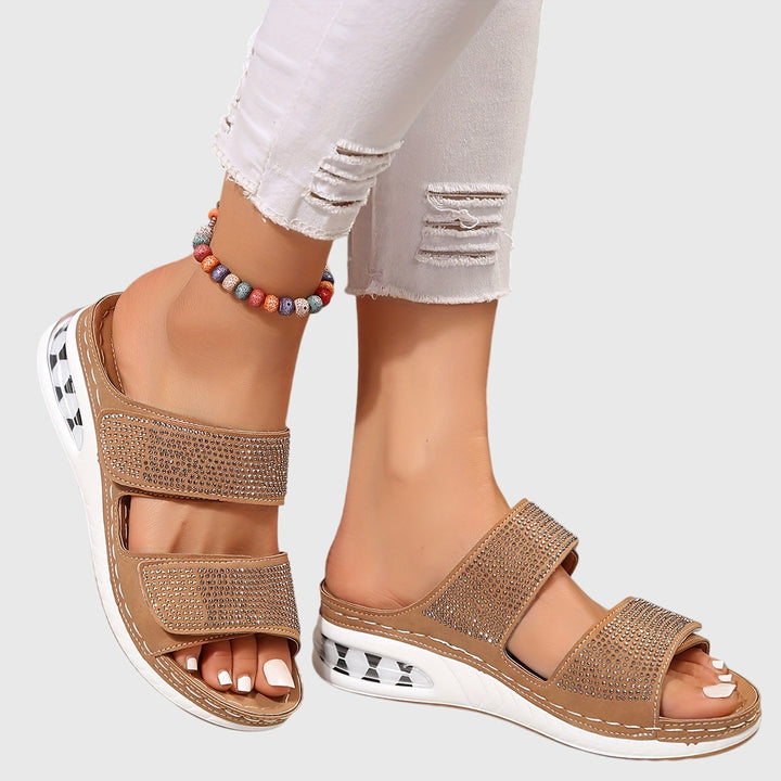 A woman standing confidently in cushioned arch-support sandals with a wide, roomy fit.