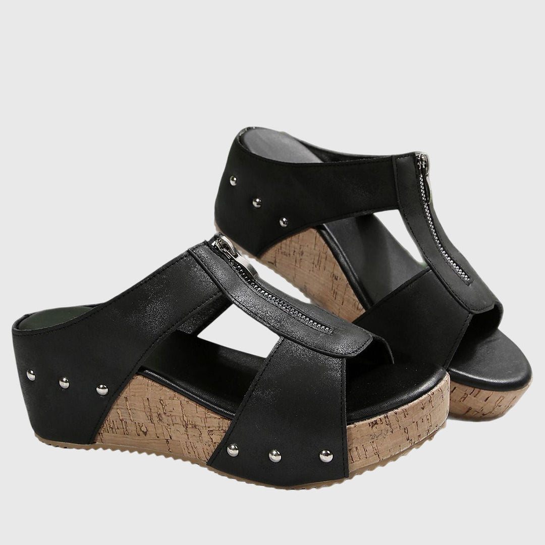 A woman standing comfortably in brown supportive sandals with an adjustable strap and cushioned sole.