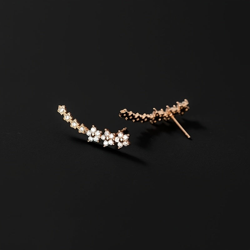 Rose gold floral crawler earrings with delicate sparkling floral motif following the curve of the ear