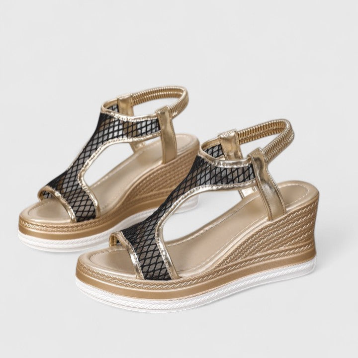 A woman wearing beige chic sandals with a cushioned sole and adjustable strap.