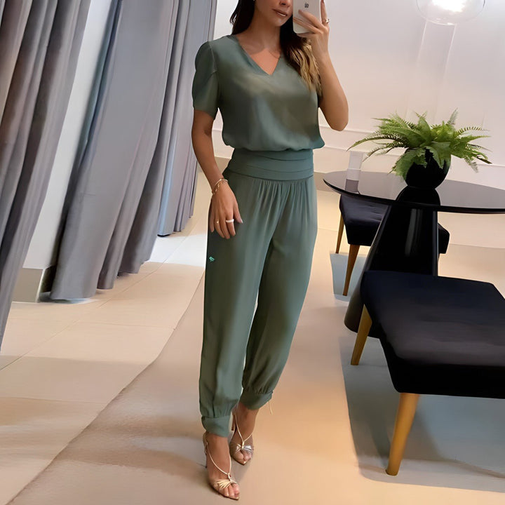 A woman wearing a plain V-neck top with geometric print slim trousers, chic and comfortable.