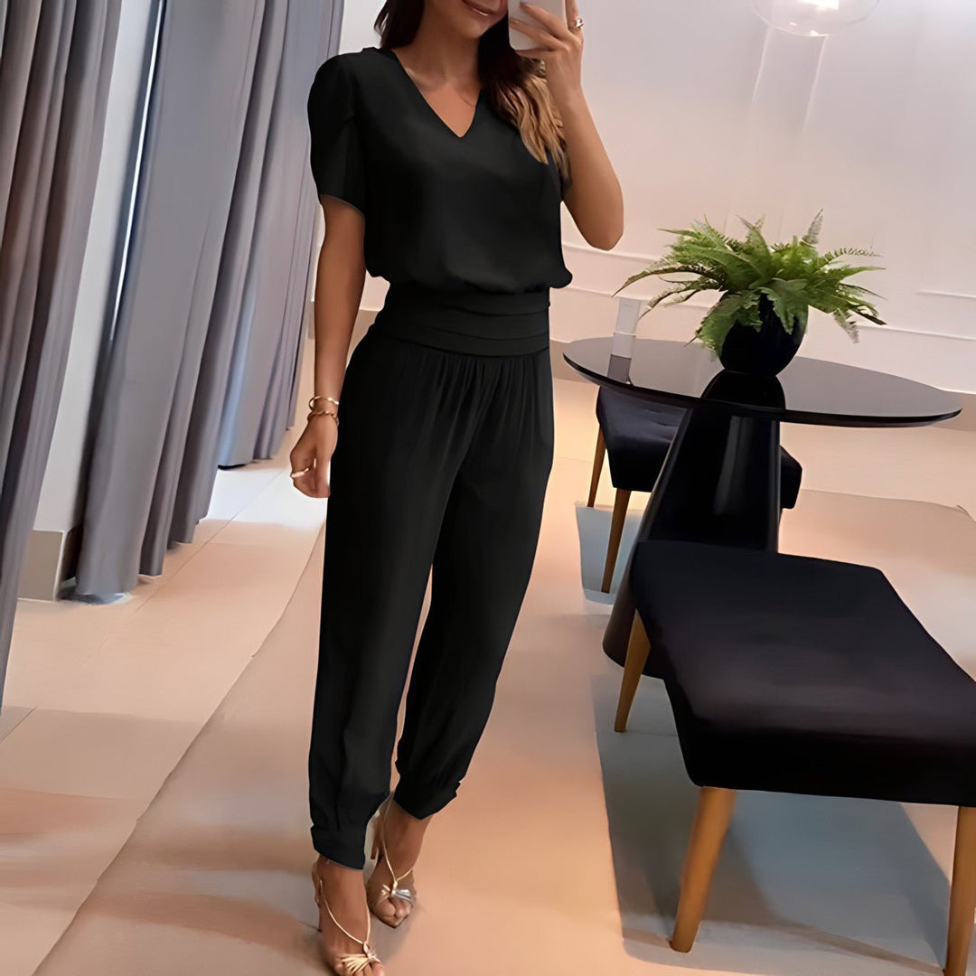 A woman wearing a plain V-neck top with geometric print slim trousers, chic and comfortable.