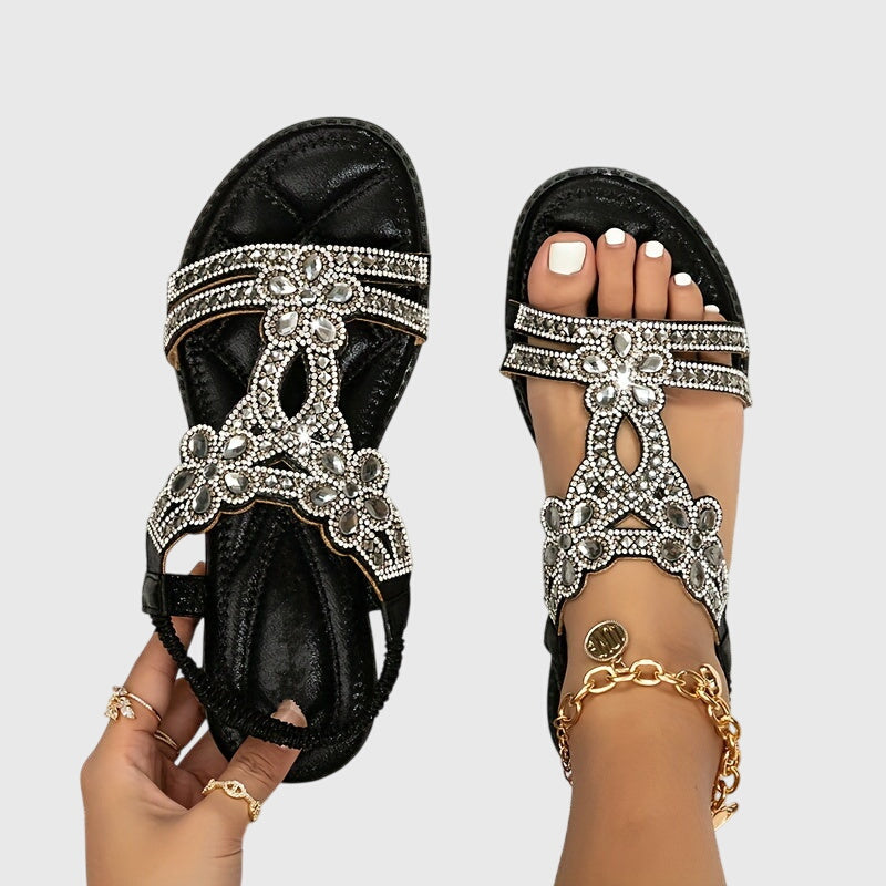 A woman wearing elegant gold open-front sandals with supportive straps and a cushioned sole.