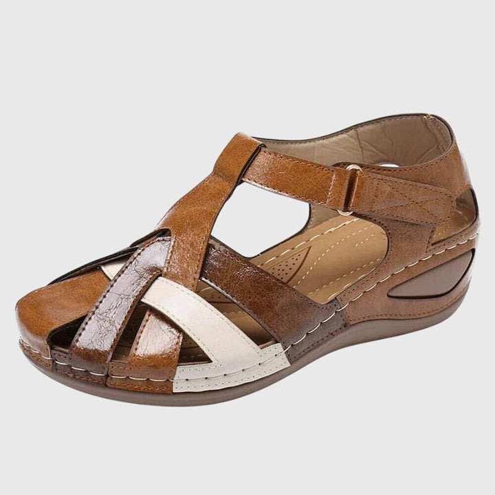 A woman in burgundy comfort sandals walking with ease on a sunny day, feet relaxed and supported.