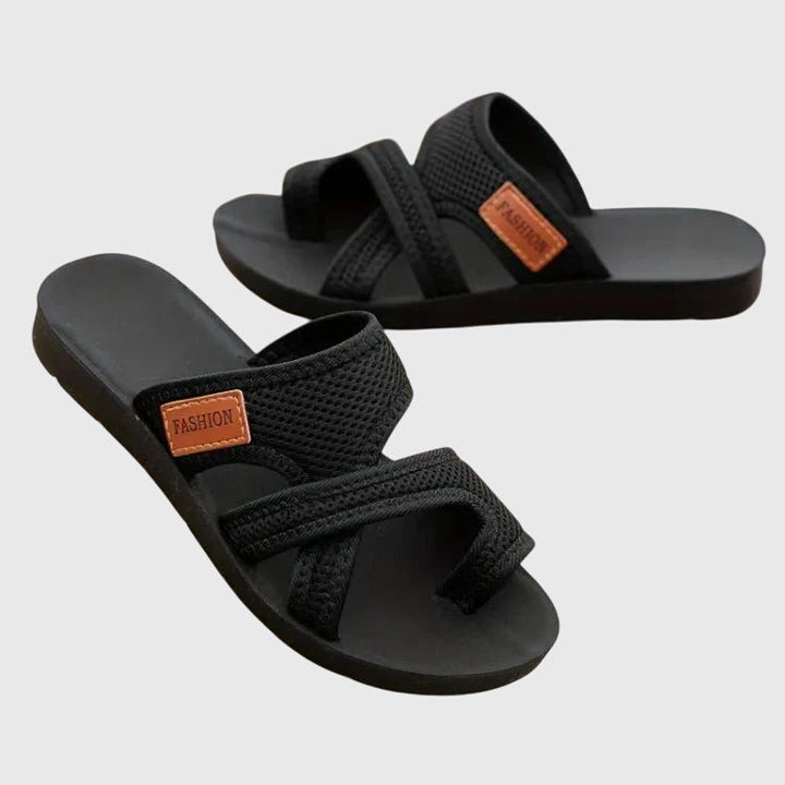 Lightweight flat sandal in black, also available in red and brown, with a simple clean design
