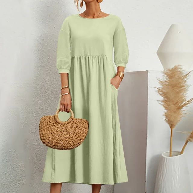 A woman wearing the Sheila fitted waist midi dress with three-quarter sleeves and a flowing skirt.