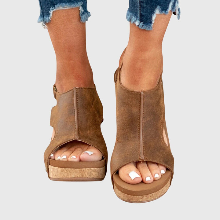 A woman in taupe wedge sandals with an open front, out shopping on a warm day.