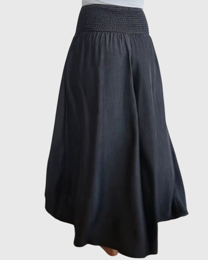 A woman in wide-leg trousers with a high elastic waist, styled for a relaxed boho look.