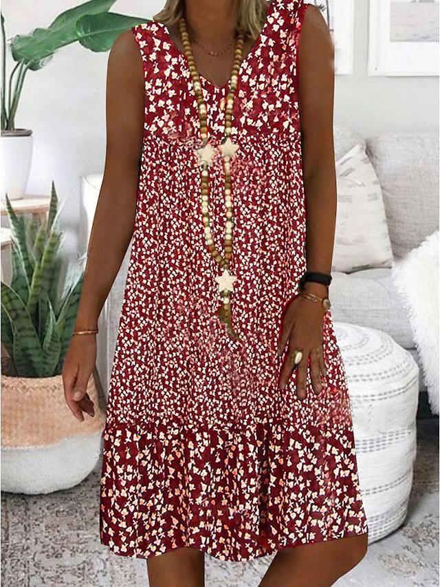 A woman wearing the Geraldine sleeveless V-neck floral dress on a sunny day outdoors.