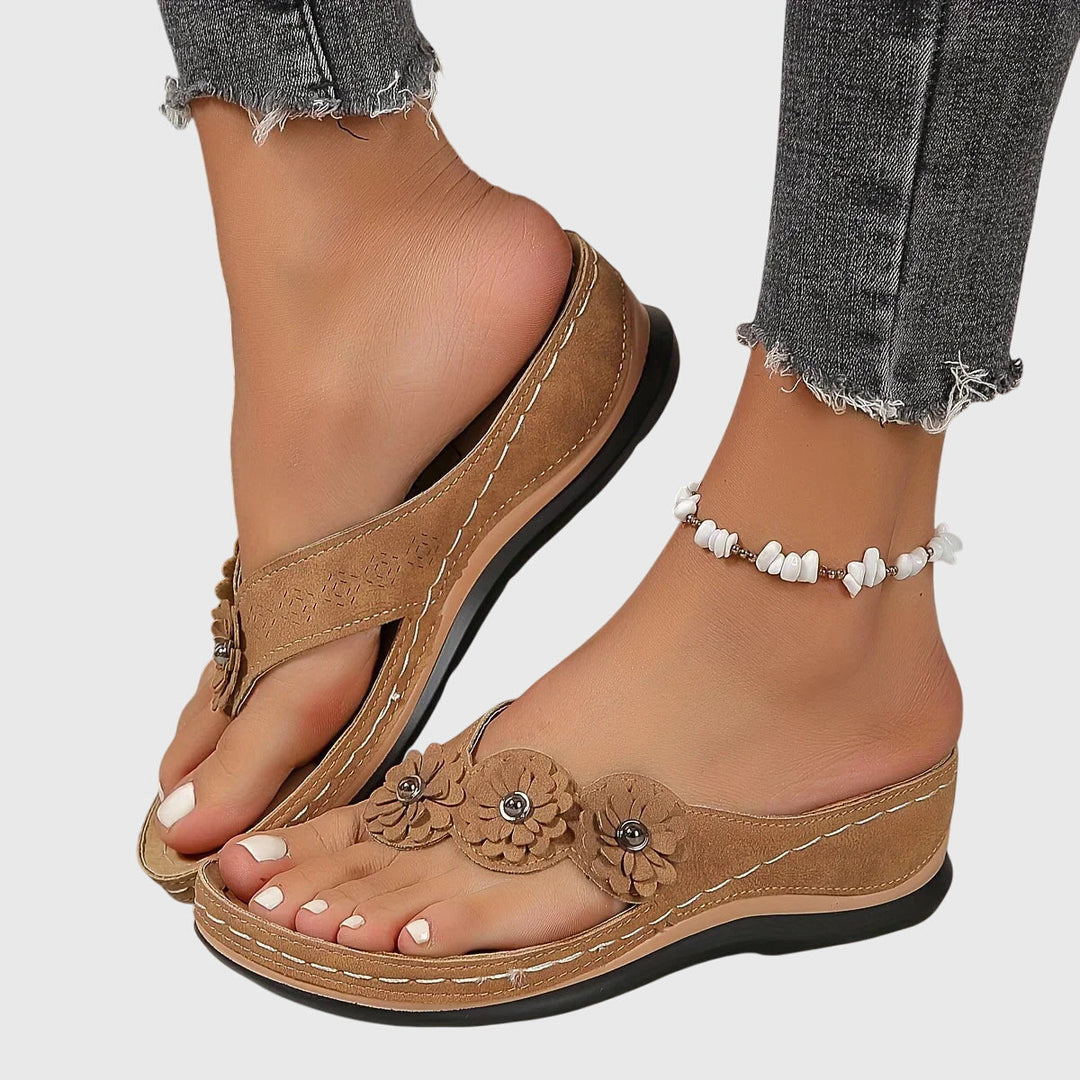 A woman wearing navy cushioned flip-flops with a supportive insole and open-front design.