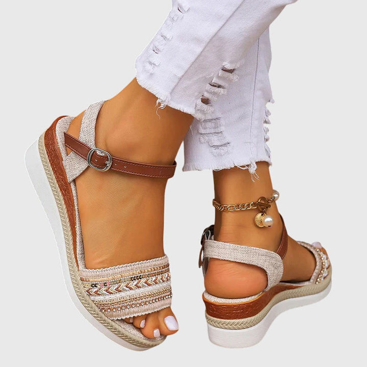 A woman walking easily in lightweight modern sandals in a soft white and brown finish.