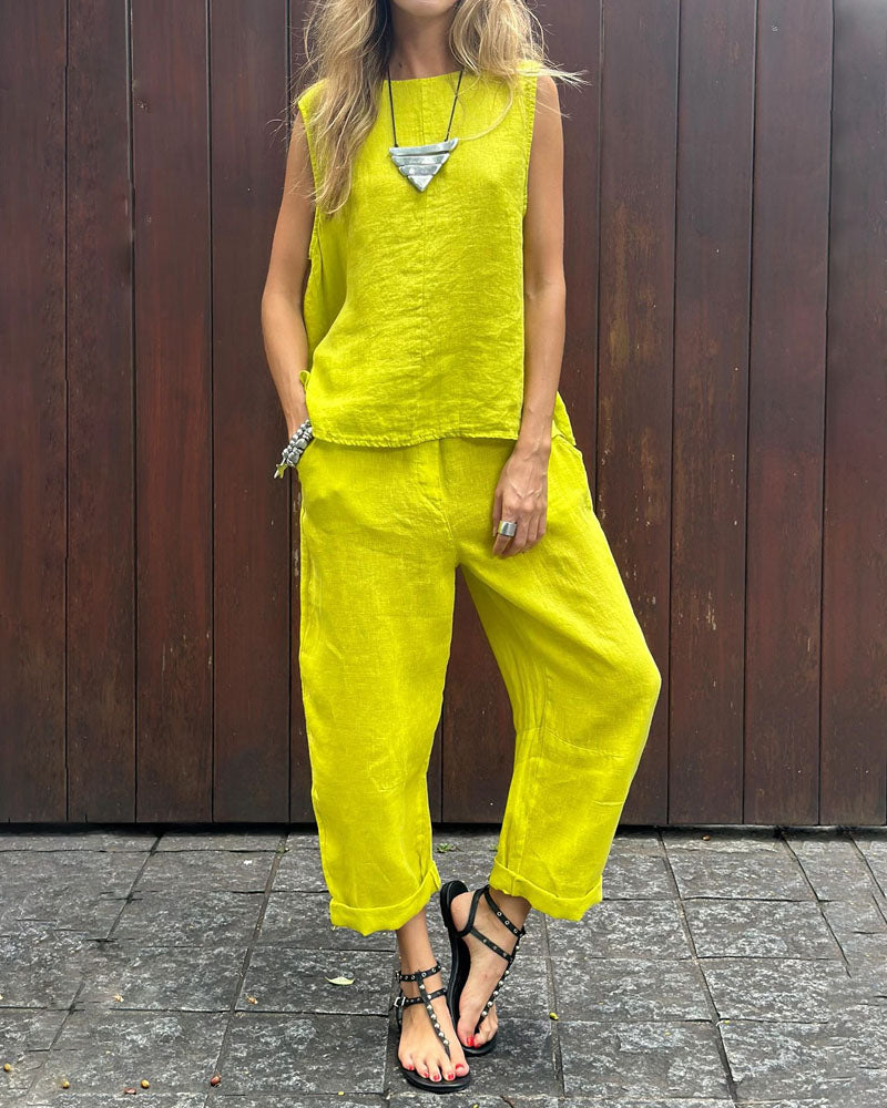 A woman wearing a relaxed sleeveless top with ankle-length trousers, easy and elegant.