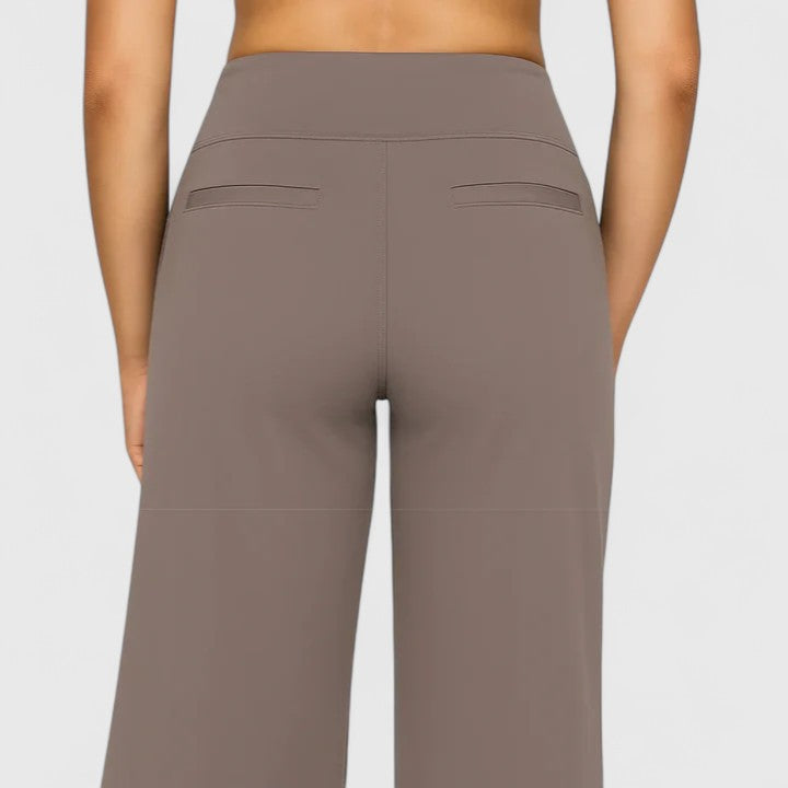 Woman wearing pull-on trousers with a soft blouse, relaxed and comfortable at home.
