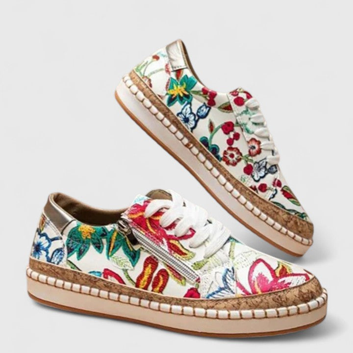 A woman wearing floral lace-up orthopaedic trainers with a side zip and platform sole.