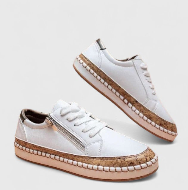A woman wearing floral lace-up orthopaedic trainers with a side zip and platform sole.