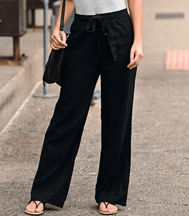 Woman wearing relaxed drawcord-waist trousers with a smart top, out for the day.