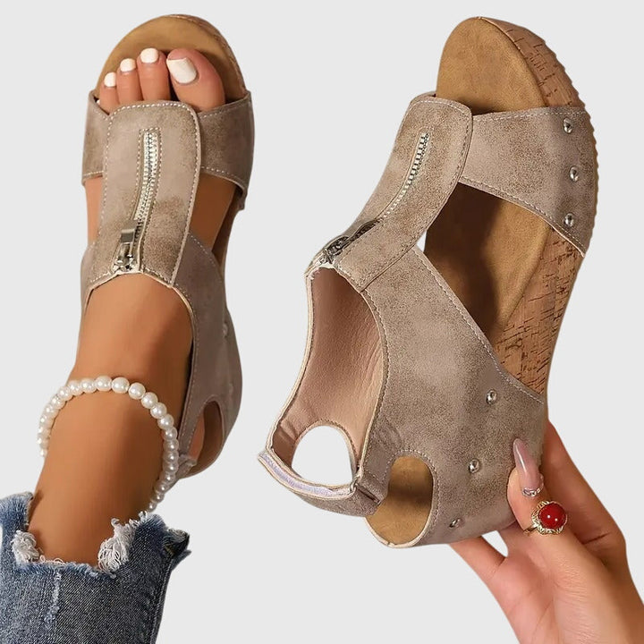 A woman standing at ease in wide-fit supportive comfort sandals with adjustable straps.