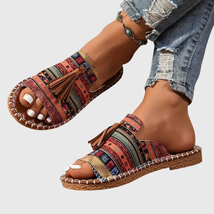 Flat boho sandals with colourful printed upper and swinging fringe detail