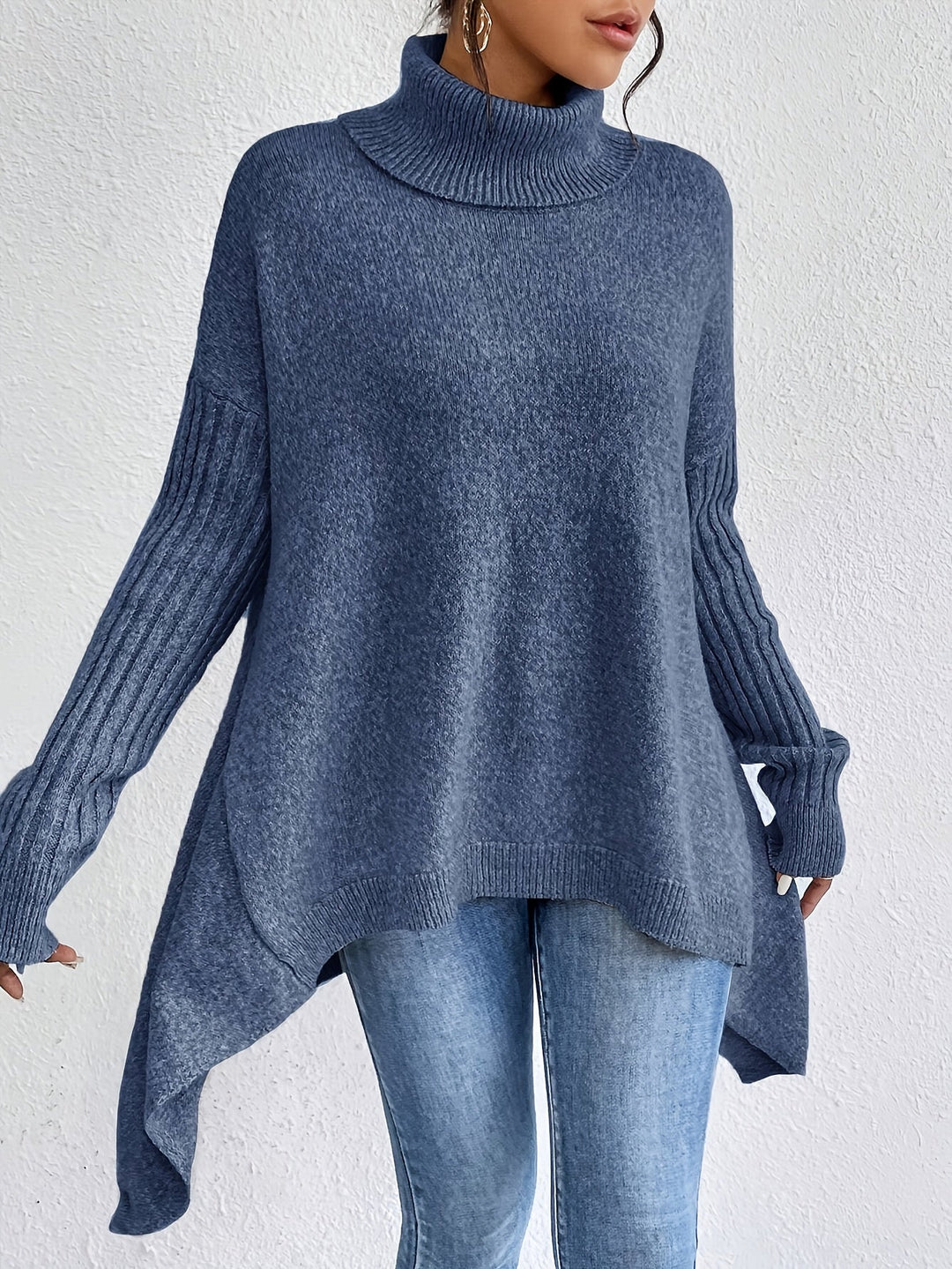 A woman wearing a stand-collar jumper with a chic asymmetric drape, warm and polished.