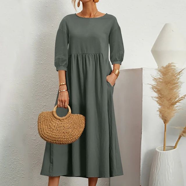 A woman wearing the Sheila fitted waist midi dress with three-quarter sleeves and a flowing skirt.