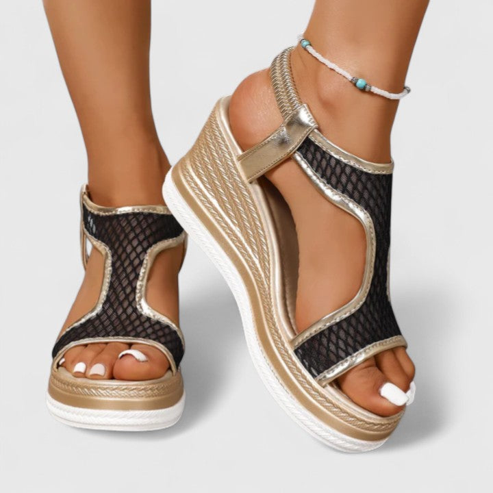 A woman wearing beige chic sandals with a cushioned sole and adjustable strap.