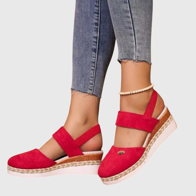 Black closed-toe wedge espadrilles with a wide stretch strap and a braided-trim platform wedge.