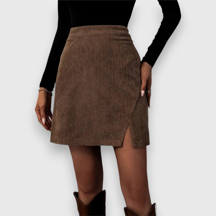 A woman in a textured ribbed skirt with a front slit, styled with a jumper for a relaxed autumn look.