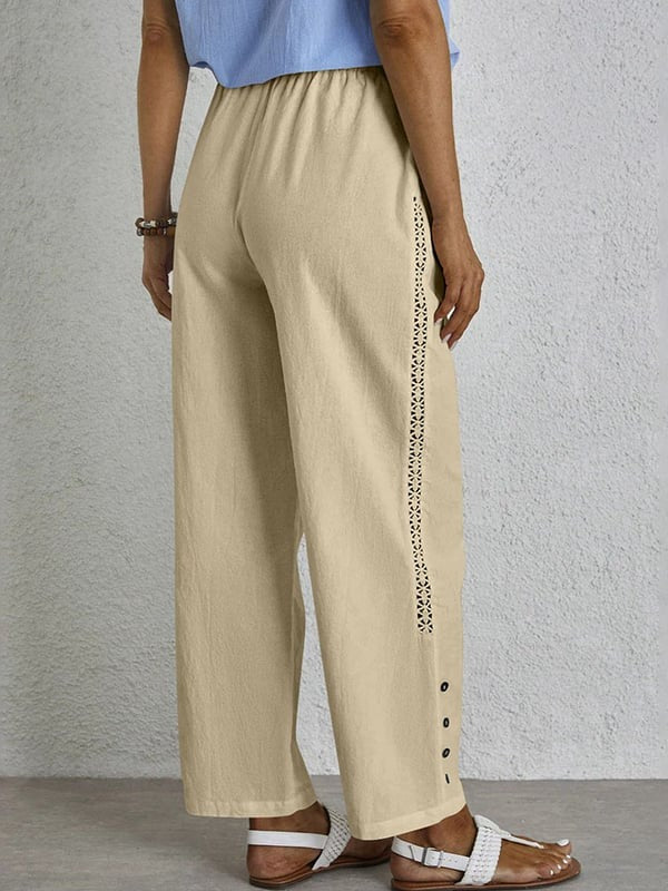 Woman wearing relaxed button-detail trousers with a simple top, out for the day.