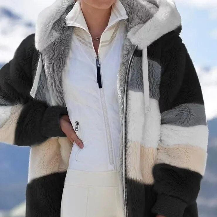 A woman wearing a hooded jacket with side pockets on a cold, rainy day out.