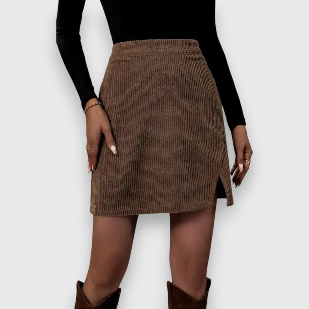 A woman in a textured ribbed skirt with a front slit, styled with a jumper for a relaxed autumn look.