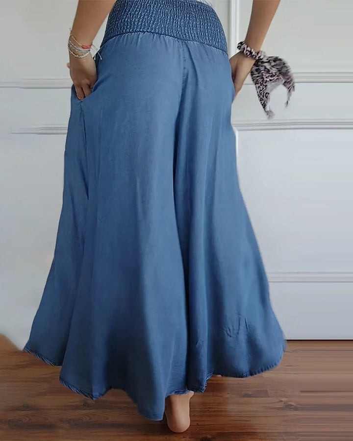 Woman wearing high-waist wide-leg trousers with a tucked-in blouse, mid-stride.