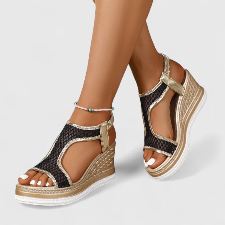 A woman wearing beige chic sandals with a cushioned sole and adjustable strap.