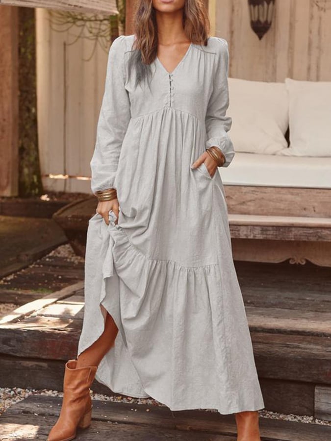 Woman walking through the countryside in the Georgia tiered maxi dress with long sleeves and a flowing flounced hem.
