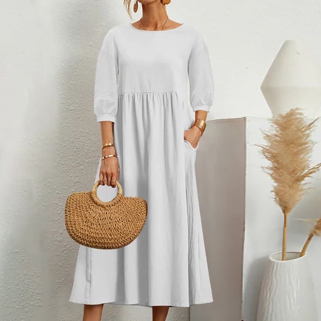 A woman wearing the Sheila fitted waist midi dress with three-quarter sleeves and a flowing skirt.