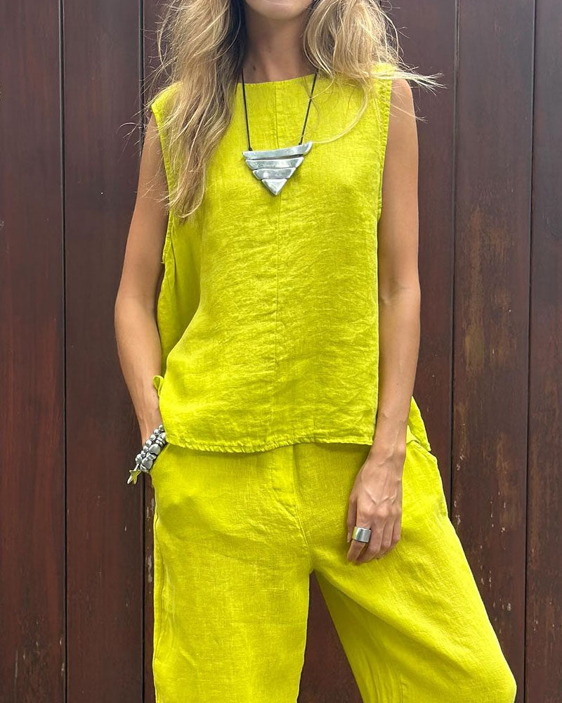 A woman wearing a relaxed sleeveless top with ankle-length trousers, easy and elegant.