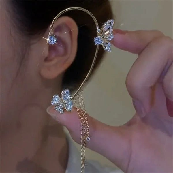 Gold celestial arc earring with a butterfly detail, framing the ear with sparkling luminosity