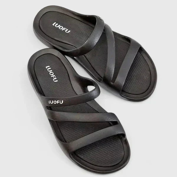 A woman walking confidently outdoors in supportive, cushioned orthopaedic sandals.