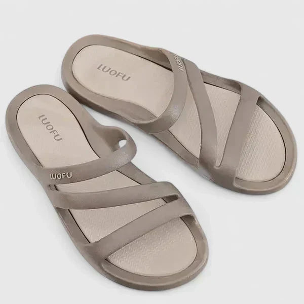 A woman walking confidently outdoors in supportive, cushioned orthopaedic sandals.