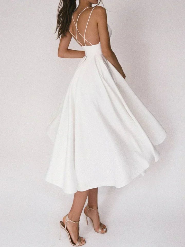 Woman at a summer celebration wearing the Katie minimalist maxi dress with fine double straps and a floating skirt.