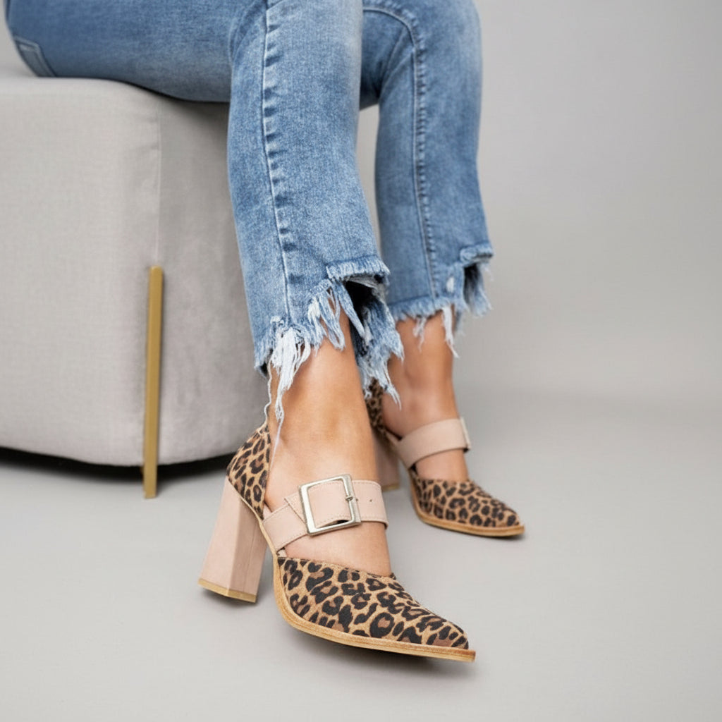 A woman wearing khaki pointed-toe high heels at a smart occasion.