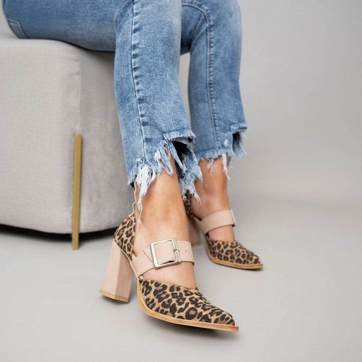 A woman wearing khaki pointed-toe high heels at a smart occasion.
