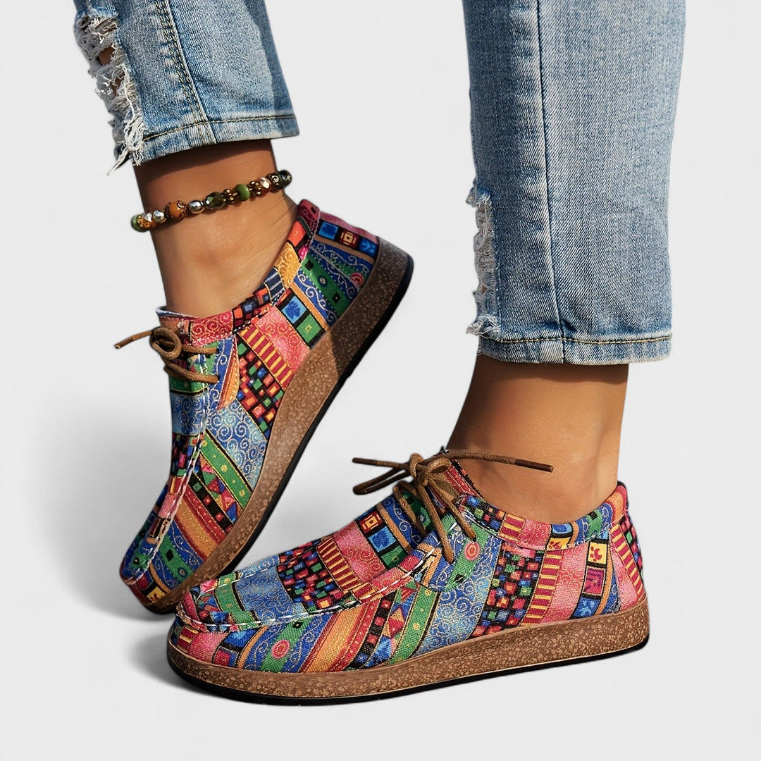 A woman wearing green boho-patterned lightweight trainers on a walk in town.