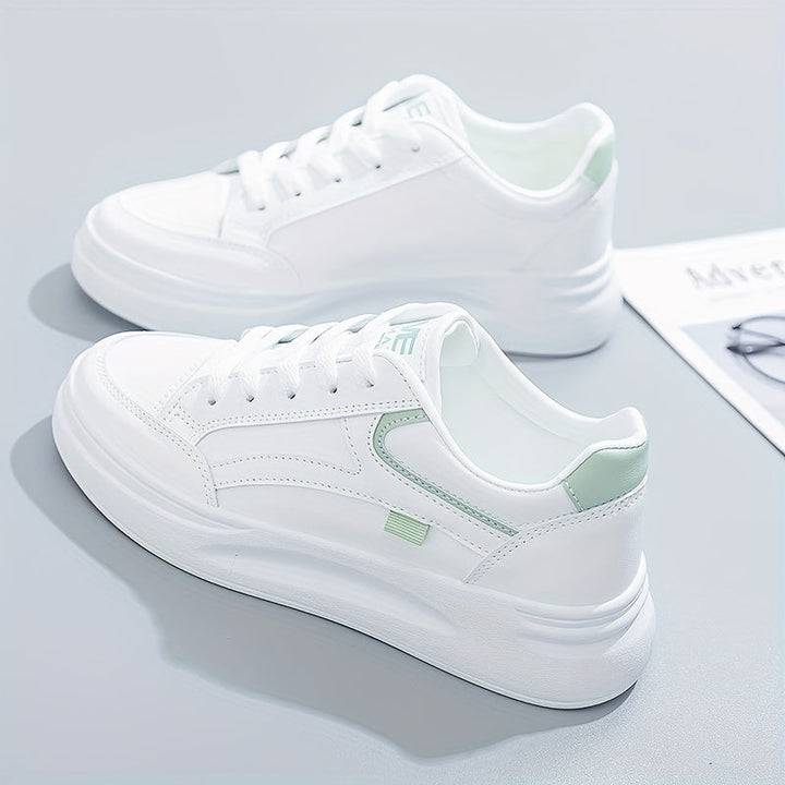 A woman in crisp white light comfort trainers paired with jeans.