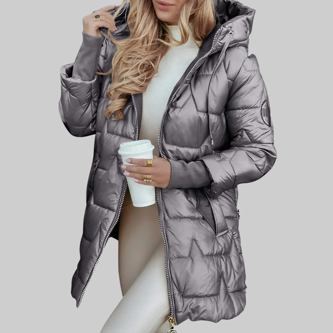 A woman wearing a hooded autumn coat in a timeless tone, sheltered from the wind.