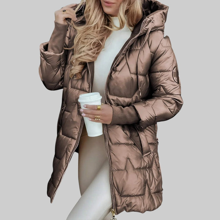 A woman wearing a hooded autumn coat in a timeless tone, sheltered from the wind.
