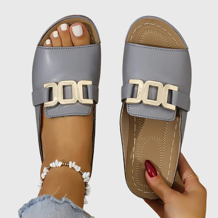 Minimalist flat sandals in beige and white with a clean, simple strap design
